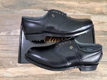 FootJoy style 51011: Plain toe blucher with kiltie, steel spikes. Pebbled Black/Smooth Black saddle